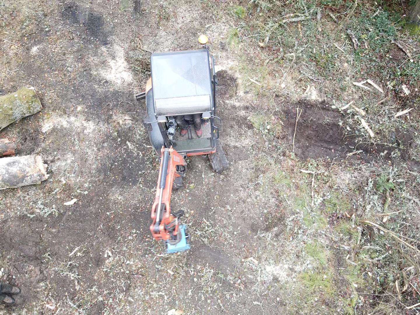 aerial view excavator with grapple attachment in clearing